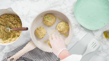 Düz yatıyordu. Adım adım. Küçük bir tavada zeytinyağında kabak keki kızartıyorum..