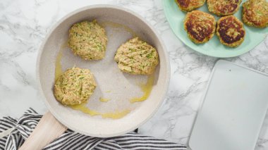 Düz yatıyordu. Adım adım. Küçük bir tavada zeytinyağında kabak keki kızartıyorum..