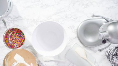 Düz yatıyordu. Adım adım. Dijital mutfak terazisinde funfetti kek hamuru ölçüyorum..