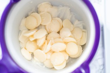 Çikolata parçacıklarını eriterek..