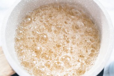 Ev yapımı lolipop yapmak için tencerede karamelize şeker.