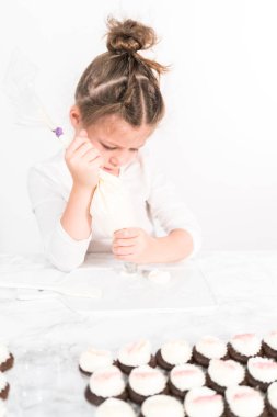 Küçük kız İtalyan tereyağı kreması tatlandırması yapıyor..