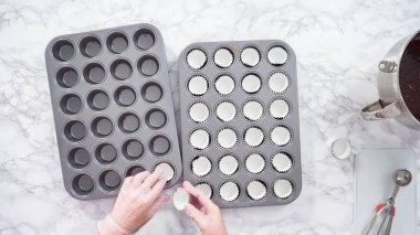 Düz yatıyordu. Adım adım. Mini çikolatalı kek pişirmek için kek kalıplarıyla kek tepsisi hazırlıyorum..