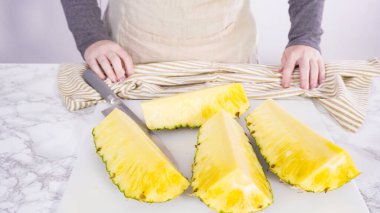 Adım adım. Beyaz bir kesme tahtasıyla ananas kesmek.