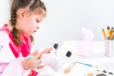 Küçük kız COVID-19 salgınında evde uzaktan öğrenim için sanat projesi üzerinde çalışıyor..
