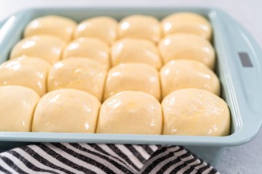 Fırında pişirmeden önce yumurta ve süt karışımıyla yemek rulolarını fırçalamak.