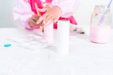 Tuvalet kağıdından tek boynuzlu at yapan küçük bir kız..