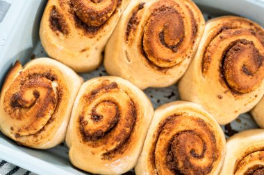 Mavi bir tavada taze pişmiş tarçınlı rulo..