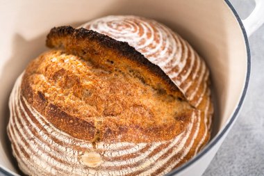 Taze pişmiş buğday ekmeği ekmeği ekmeği, içinde ekmek yalıtımı sepeti ve dökme demir fırın izleri var..