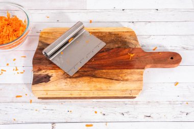 Ağaç kesme tahtasında rendelenmiş organik turuncu havuç..