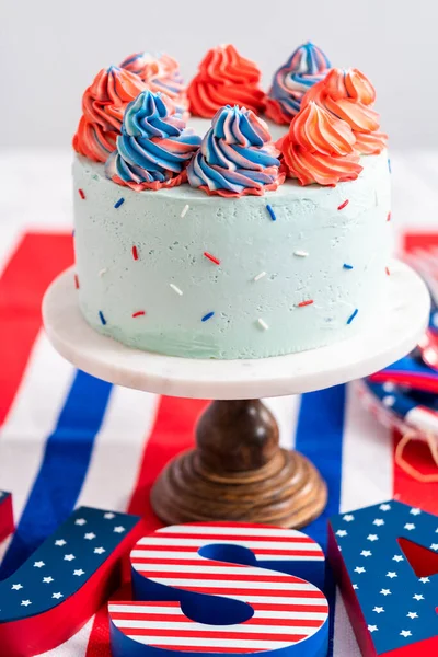 7月4日のお祝いのためにバタークリームの霜降りと赤 青のラウンドバニラケーキ — ストック写真