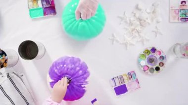 Düz yatıyordu. Adım adım. Süslü deniz kızı Cadılar Bayramı balkabağı yaratmak için akrilik boyalı balkabağı boyamak.