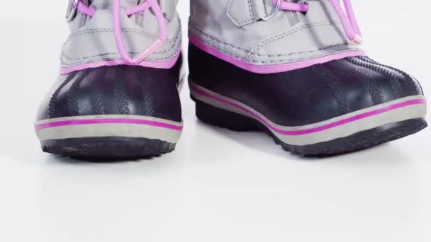 小さな女の子ピンクとグレー暖かいと防水冬のブーツ上の白い背景 — ストック動画