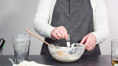 Adım adım. Şekerli kurabiyeleri süslemek için kraliyet kremasına gıda boyası karıştırmak..