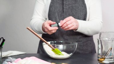 Adım adım. Şekerli kurabiyeleri süslemek için kraliyet kremasına gıda boyası karıştırmak..