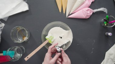 Adım adım. Düz yatıyordu. Şekerli kurabiyeleri süslemek için kraliyet kremasına gıda boyası karıştırmak..