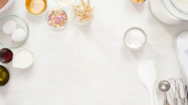 Düz yatıyordu. Adım adım. Tek boynuzlu at çikolatalı kekleri tereyağlı kremayla karıştırmak için karışımı beyaz bir kasede karıştırıyorum..