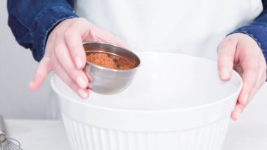 Adım adım. Tek boynuzlu at çikolatalı kekleri tereyağlı kremayla karıştırmak için karışımı beyaz bir kasede karıştırıyorum..