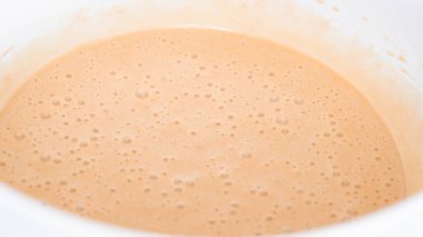 Adım adım. Tek boynuzlu at çikolatalı kekleri tereyağlı kremayla karıştırmak için karışımı beyaz bir kasede karıştırıyorum..