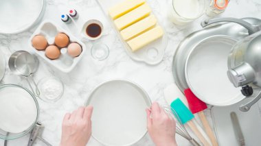 Adım adım. Düz yatıyordu. Üç katlı vanilyalı kek pişirmek için tereyağlı kek tavaları yağlamak..