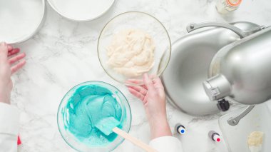 Adım adım. Düz yatıyordu. Üç katlı vanilyalı kek pişirmek için yemek boyasını kek hamuruna karıştırıyorum..