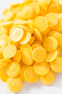 Eriyen çikolata şekilleri için sarı yuvarlak çikolata parçaları..