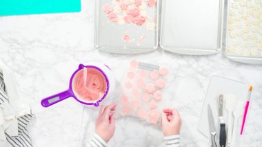 Düz yatıyordu. Adım adım. Erimiş çikolatayı kar taneleri şeklinde plastik bir çikolata kalıbına döküyorum..