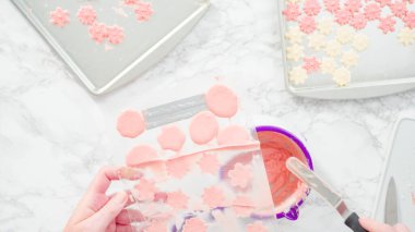 Düz yatıyordu. Adım adım. Erimiş çikolatayı kar taneleri şeklinde plastik bir çikolata kalıbına döküyorum..