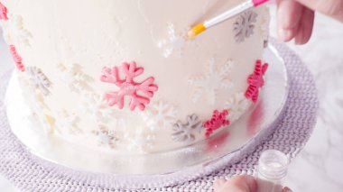 Adım adım. Yuvarlak funfetti pastasını pembe ve beyaz fondant kar taneleriyle süslüyorum..
