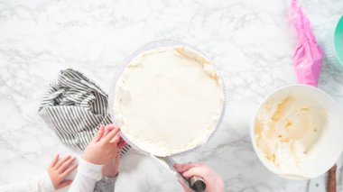 Düz yatıyordu. Adım adım. Beyaz İtalyan kremalı, yuvarlak funfetti keki..