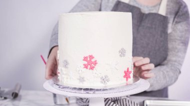 Adım adım. Yuvarlak funfetti pastasını pembe ve beyaz fondant kar taneleriyle süslüyorum..