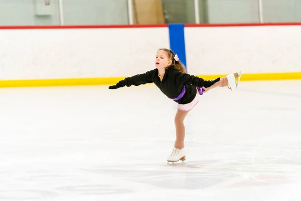 Kleines Mädchen Übt Eiskunstlauf Auf Einer Überdachten Eisbahn — Stockfoto