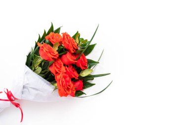 Düz yatıyordu. Beyaz arka planda kırmızı güller ve yeşil yapraklar..