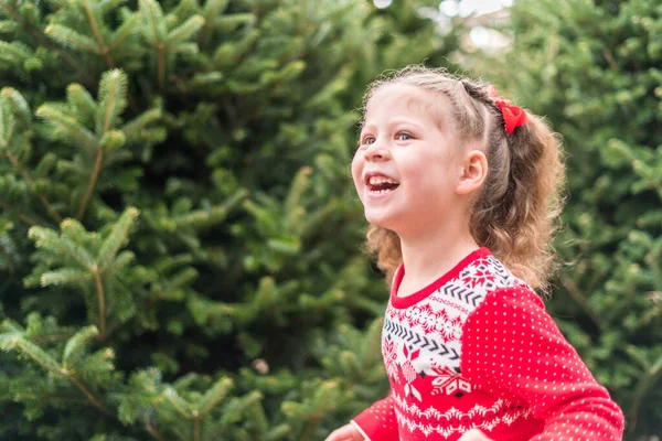 女の子で赤いドレスでクリスマスツリーファーム — ストック写真