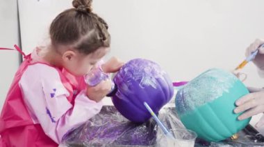 Küçük kız Cadılar Bayramı balkabağını yapay elmaslarla süslüyor..