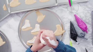 Süslü buz pateni şekilli şeker kurabiyeleri, beyaz renkli kraliyet kreması..