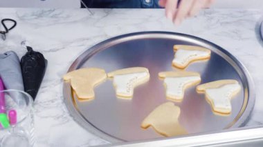 Süslü buz pateni şekilli şeker kurabiyeleri, beyaz renkli kraliyet kreması..