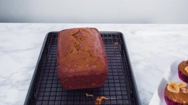 Taze pişmiş muzlu fındıklı ekmek, ev yapımı karamelli pembe kesim tahtasının üzerinde..