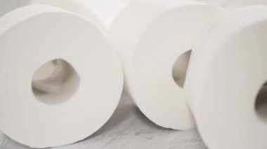 Gri arka planda yeni beyaz tuvalet kağıdı ruloları.