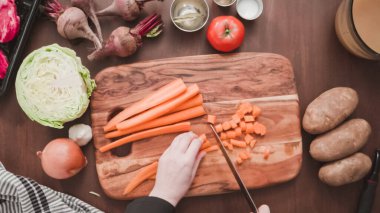 Adım adım. Düz yatıyordu. Pancar çorbası ve borş için küçük küplere portakal havucu dilimliyorum..