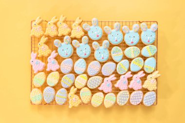 Düz yatıyordu. Farklı renklerde kraliyet kremalarıyla süslenmiş Paskalya şekerli kurabiyeler..