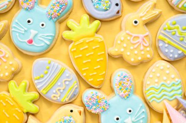 Farklı renklerde kraliyet kremalarıyla süslenmiş Paskalya şekerli kurabiyeler..