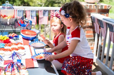Küçük kızlar arka verandadaki 4 Temmuz partisinde oynuyorlar..