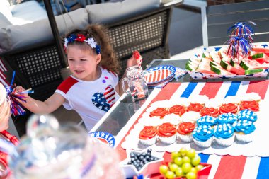 Küçük kızlar arka verandadaki 4 Temmuz partisinde oynuyorlar..