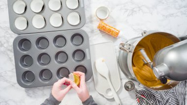Düz yatıyordu. Balkabağı aromalı kek hamuru. Hamur hamuru kepçesiyle kapkek tepsisine dolgu malzemesi..