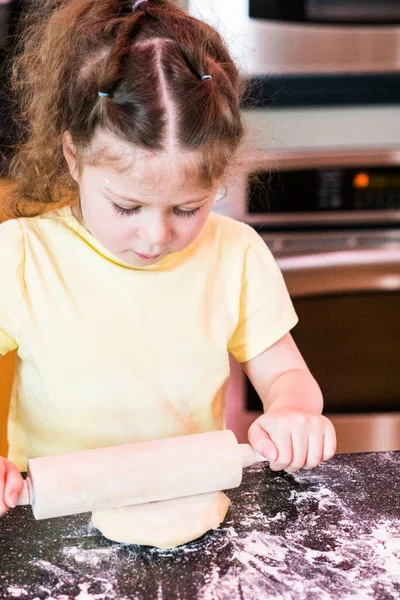 Kleines Mädchen Rollt Zuckerkekse Teig Mit Nudelholz Auf Dem Küchentisch — Stockfoto