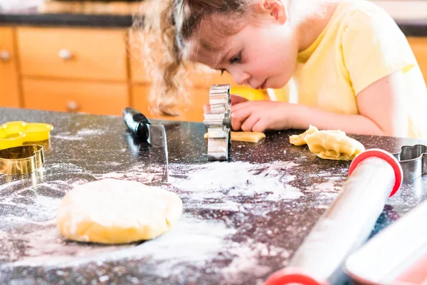 台所で砂糖クッキーを焼く女の子 — ストック写真