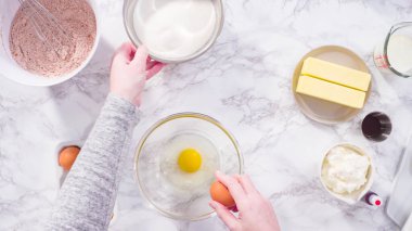 Düz yatıyordu. Adım adım. Kırmızı kadife kek pişirmek için bardakta ıslak malzemeler karıştırıyorum..