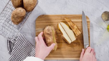 Düz yatıyordu. Adım adım. Fırında pişirmek için zeytinyağı ve baharatla patates dilimliyorum..