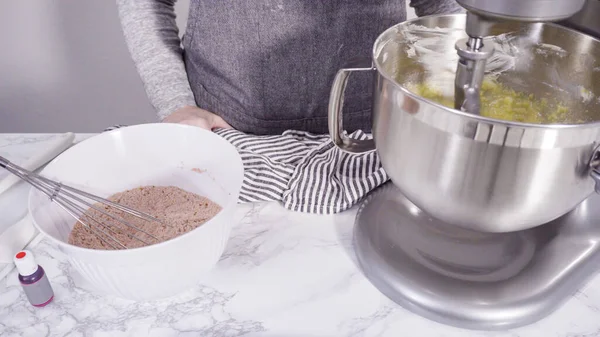 Step by step. Mixing ingredients in a standing kitchen mixer to bake red velvet cupcakes.